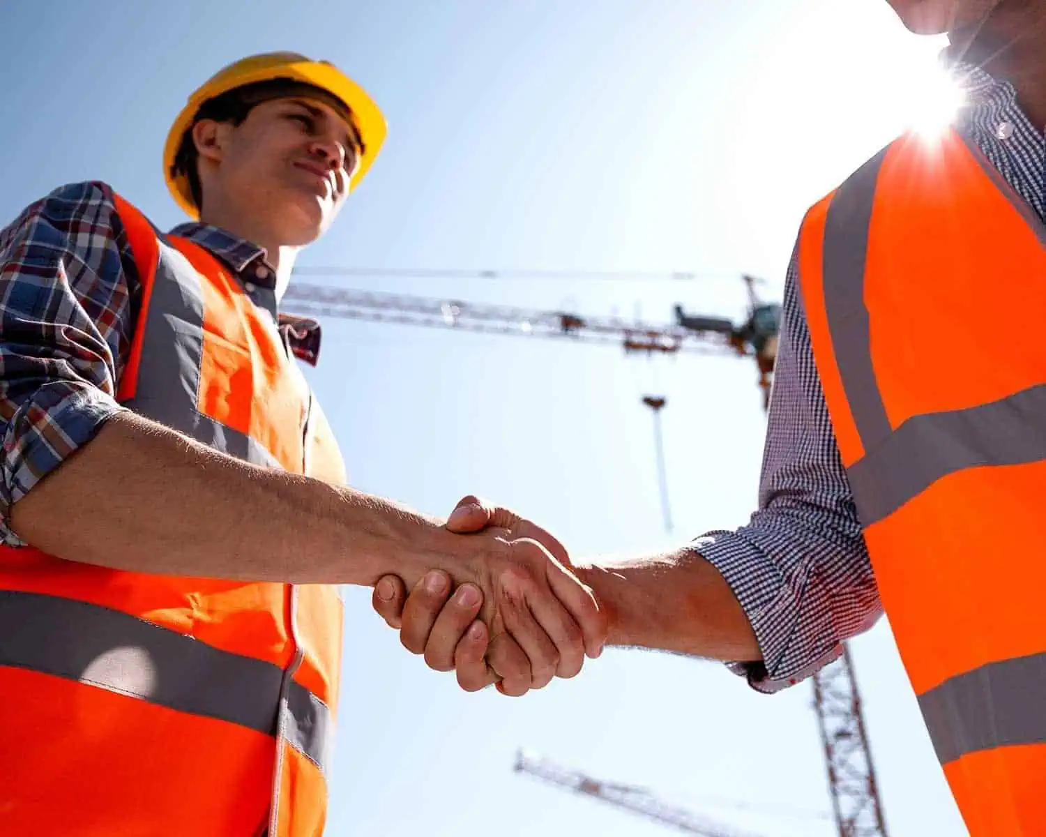 Construction handshake between two workers at a building site.
