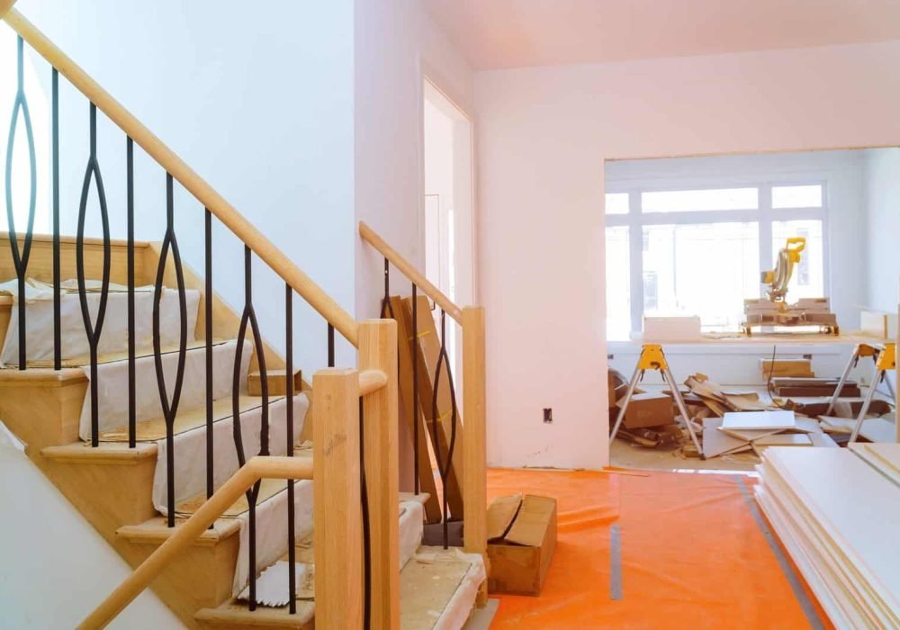 Interior renovation with staircase and construction materials in progress.