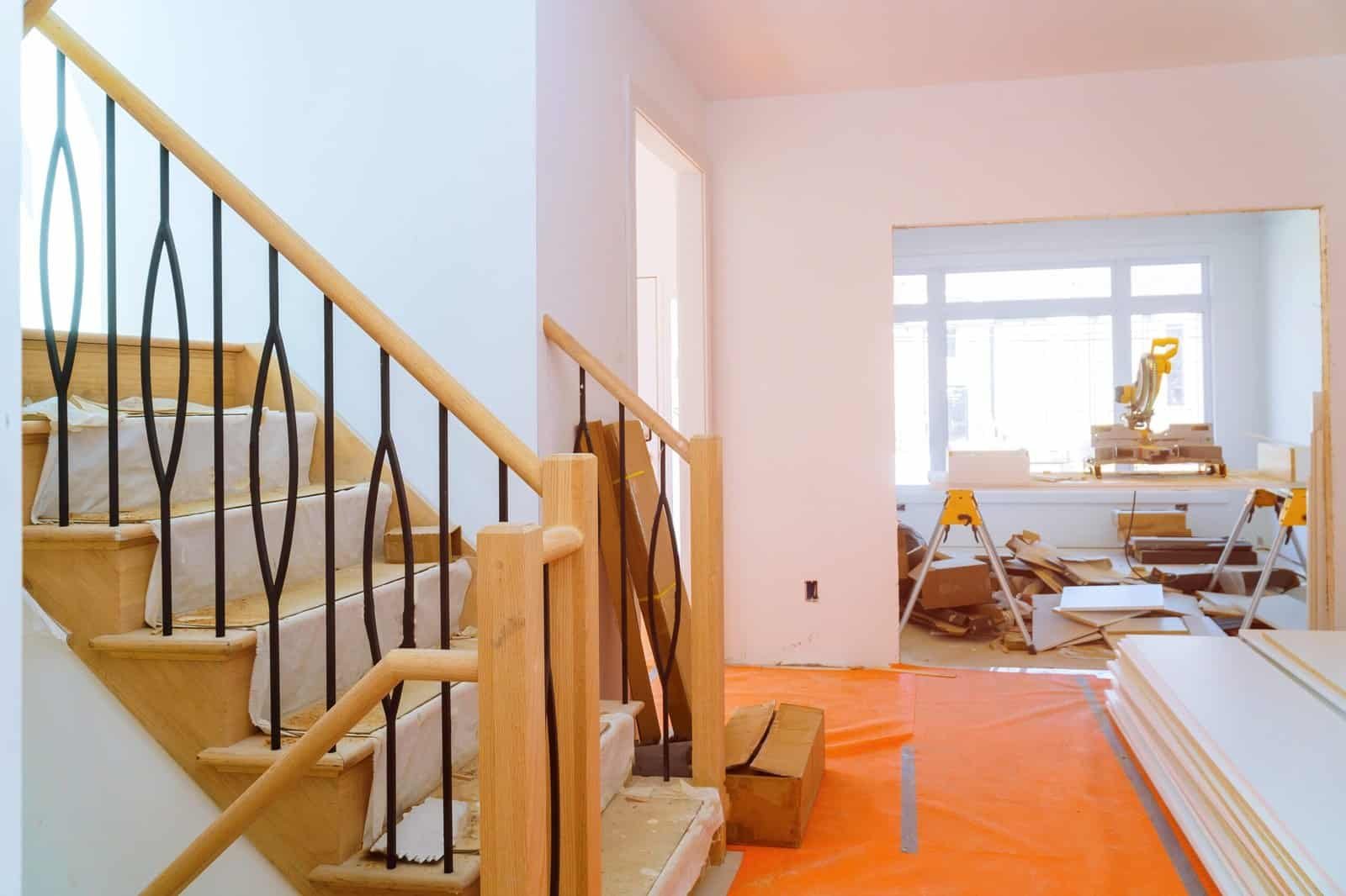 Interior renovation with staircase and construction materials in progress.